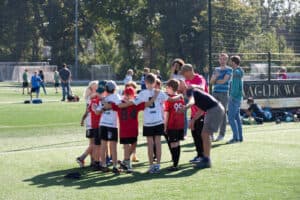 A youth team huddled together with their coach